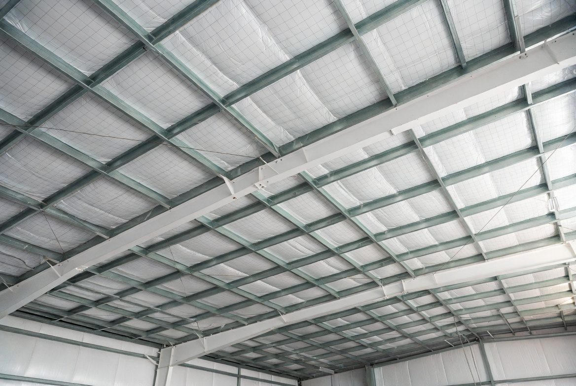 White faced insulation installed under metal building roof structure