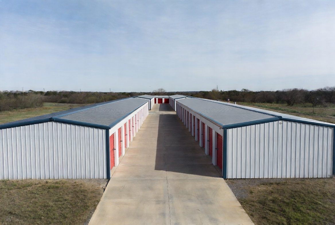 Self-storage complex with drive aisle between two metal mini storage buildings